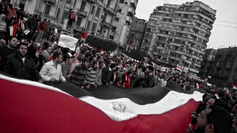 Tahrir Meydanı'nda protestocular bayrak sallıyor.