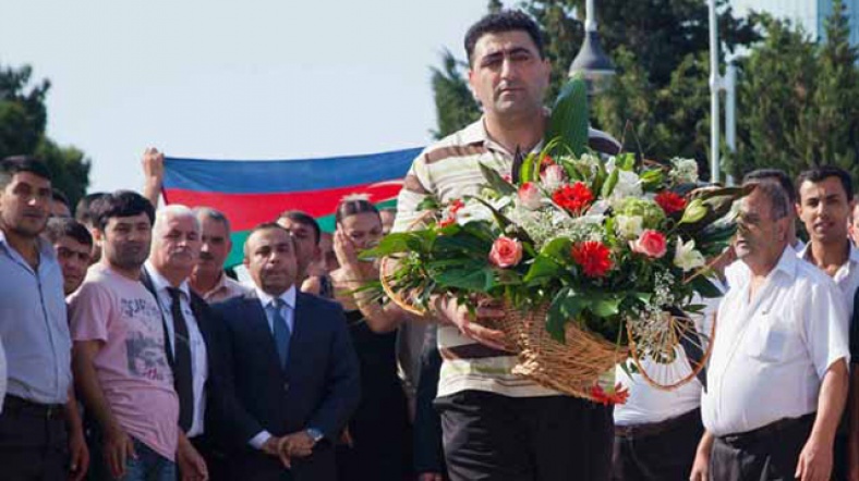 Ramil Safarov elinde bir buket gül ile kendisini karşılayanları selamlıyor.