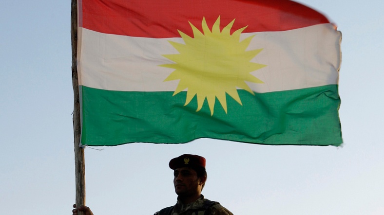 Irak Kürdistanı Bölgesel Yönetimi bayrağı taşıyan bir Peşmerge.