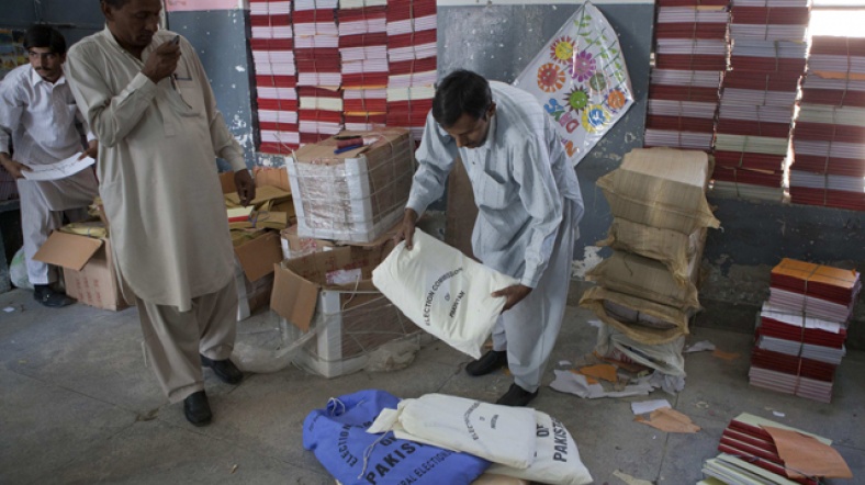 Pakistan'da seçim pusulaları ve sandıkları, oy verme noktalarına dağıtılmak üzere tasnif ediliyor.