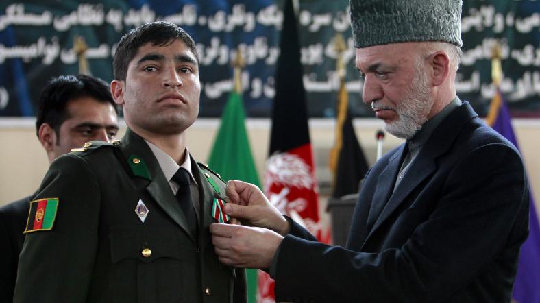 Afganistan Cumhurbaşkanı Hamid Karzai bir Afgan askerine madalya takıyor.