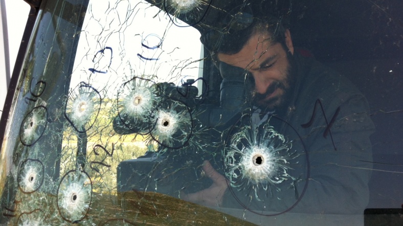 AJT kameramanı Alper Çakıcı, Suriye'de silahlı saldırıya uğrayan Suphi Ezer'e ait TIR'ın camını görüntülüyor.