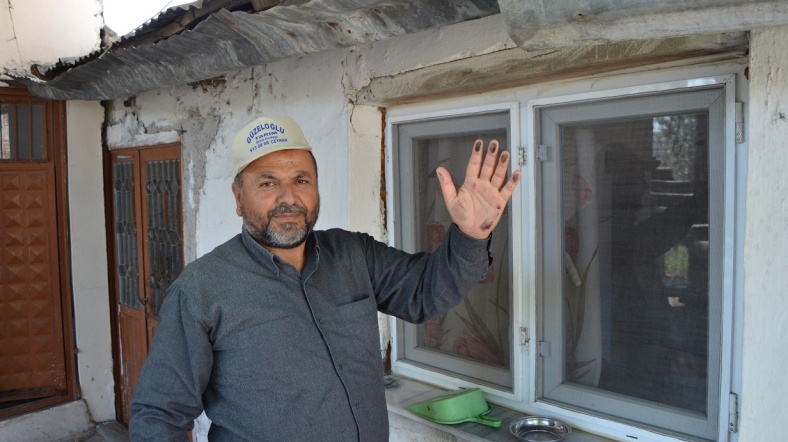 recep tosun, kömür tozundan şikayetçi. tüm köy kömür tozuyla kaplı diyerek, evin penceresindeki tozu gösteriyor. [fotorğaf: okan yüksel / al jazeera]