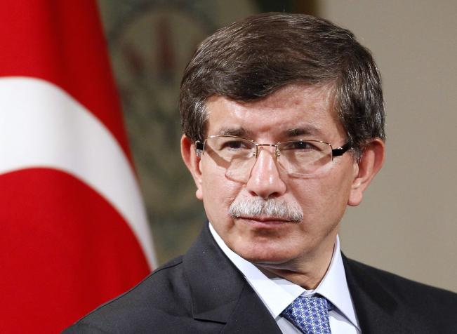 Ahmet Davutoğlu Türkiye bayrağının önünde.