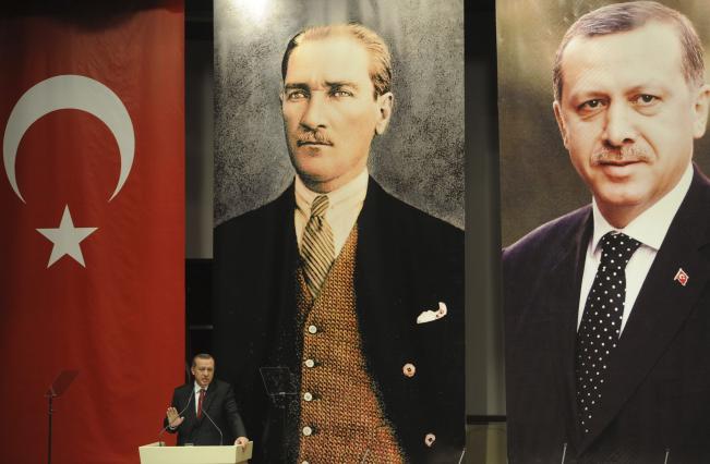 Erdoğan Atatürk ve kendi posteri önünde konuşma yapıyor.