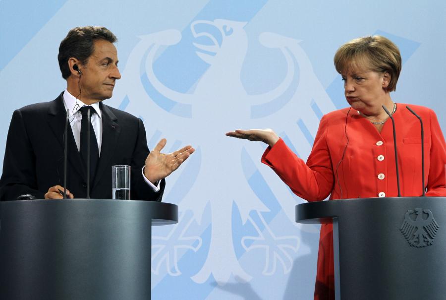Sarkozy ve Merkel kürsüde birbirlerine bakıyor.